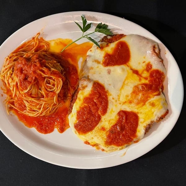 Chicken parmesan with melted cheese and marinara sauce, served with a side of spaghetti.